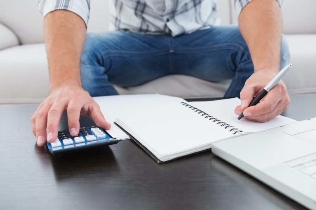 A businessman working on his finances at a table at his home